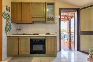 a kitchen with wooden cabinets and a stove at Via Mazzini 87 in Calasetta