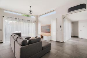 a living room with a couch and a television at Villa de standing piscine 10 pers in Bruz