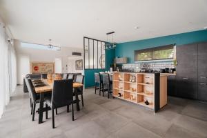 a kitchen and dining room with a table and chairs at Villa de standing piscine 10 pers in Bruz