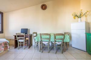a dining room with a table and chairs and a refrigerator at Via Mazzini 87 in Calasetta