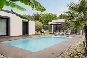 a swimming pool in a yard next to a house at Villa de standing piscine 10 pers in Bruz
