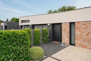 a brick building with a black door at Villa de standing piscine 10 pers in Bruz