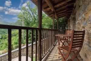 a wooden balcony with a table and chairs on it at Miradoiro do Courel - Millares in Campelo