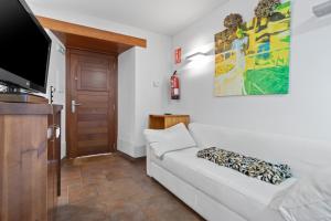 a living room with a white couch and a flat screen tv at R de Alborada del eo in Villameitide