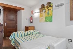 a bedroom with a bed and a painting on the wall at R de Alborada del eo in Villameitide