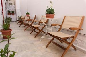 a row of chairs and tables in a room with plants at BAHIA Guest House in Hydra