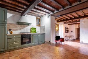 a large kitchen with green cabinets and a table at Casetta di Ugolino in Radicofani