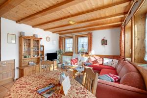 a living room with a red couch in a room at Krährbauernhof mit Hofladen in Hornberg