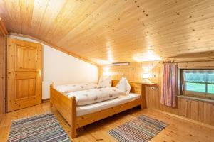 a bedroom with a bed in a wooden room at Ferienwohnung Jägermeister in Sankt Martin bei Lofer