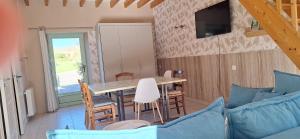 a dining room with a table and chairs at La Maisonnette du Meslay in Fyé