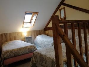 a attic bedroom with two beds and a ladder at La Maisonnette du Meslay in Fyé +21 photos