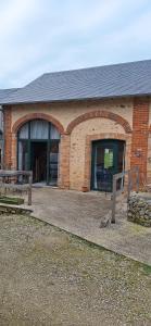 a brick building with benches in front of it at La Maisonnette du Meslay in Fyé
