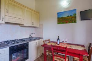 a kitchen with a red table with a bottle of wine at Stella Marina Piscina e Vista Mare in Aglientu