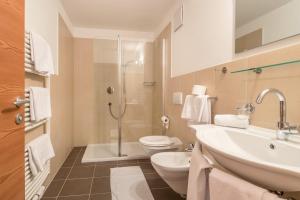 a bathroom with a sink and a toilet and a shower at Sabina Dolomites Spitzbühl in Alpe di Siusi +22 photos
