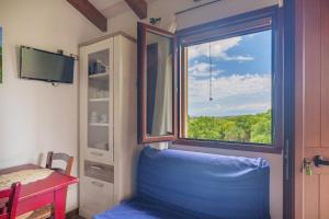 a room with a blue chair and a window at Stella Marina Piscina e Vista Mare in Aglientu