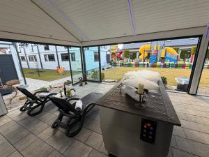 a patio with a table and chairs and a playground at Amelia Resort in Sianozety
