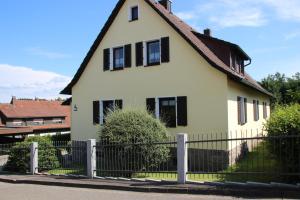 a white house with black windows and a fence at Ferienwohnung Oberpfälzer Wald in Vohenstrauß