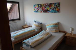 a room with two beds and a painting on the wall at Ferienwohnung Am Wehr in Georgensgmünd
