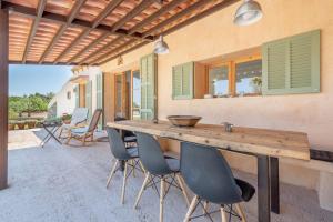 a patio with a wooden table and chairs at Finca Laurel in Islas Baleares