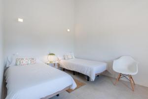 a white room with two beds and a chair at Finca Laurel in Islas Baleares +17 photos