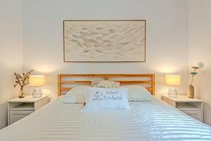 a bedroom with a white bed with two night stands at Les Terrasses de la Palud in Landéda