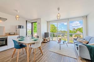 a kitchen and living room with a table and chairs at Les Terrasses de la Palud in Landéda