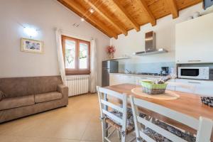 a kitchen and dining room with a table and a couch at Residence Tatiana B1 in Tremosine Sul Garda
