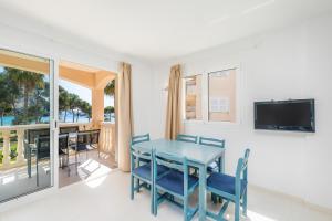 a dining room with a table and chairs and a television at Oro del Mar iv apartamento 05 in Canyamel