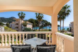 a table on a balcony with a view of the ocean at Oro del Mar iv apartamento 05 in Canyamel