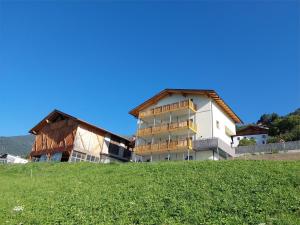 a building on top of a grassy hill at Gurschlerhof in Lasa