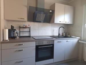 a kitchen with white cabinets and a sink and a stove at Ferienwohnung Schatzkammer in Walporzheim +15 photos