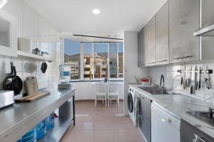 a white kitchen with a sink and a dishwasher at Playa Graciosa in Arona