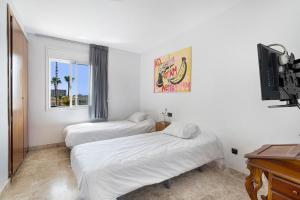 a bedroom with two beds and a tv and a window at Playa Graciosa in Arona +19 photos