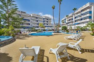 a group of chairs and a swimming pool at a resort at Playa Graciosa in Arona
