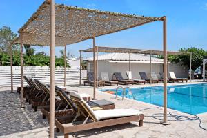 a group of lounge chairs and a swimming pool at Iguana studio 15 in Preveza