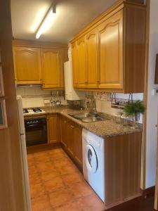 a kitchen with wooden cabinets and a washing machine at El Mirador de Llanars in Llanars