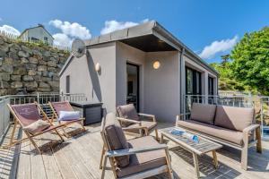 a patio with lounge chairs and a house at Les Terrasses de la Palud in Landéda