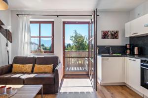 a living room with a couch and a kitchen at Wohnung Untersbergblick in Freilassing