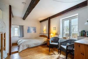 a bedroom with a bed and two chairs and a desk at Ferienwohnungen Am Westerdeich in Rodenäs
