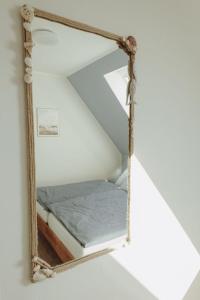 a mirror hanging on a wall with a bed in it at Gästehaus Bröcker Wohnung 8 in Büsum