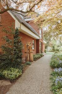 a red brick house with a tree and a driveway at Gästehaus Bröcker Wohnung 8 in Büsum