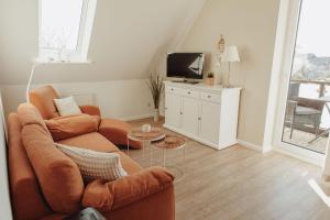 a living room with a couch and a tv at Gästehaus Bröcker Wohnung 8 in Büsum