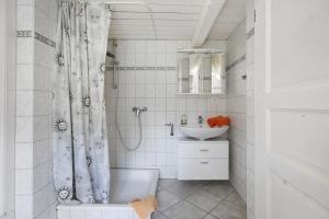 a bathroom with a shower curtain and a sink at Friesisches Reetdachferienhaus in Bordelum +18 photos