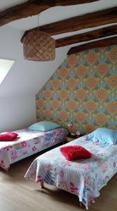 a bedroom with two beds and a wall at Aux souvenirs d'Antan in Broyes