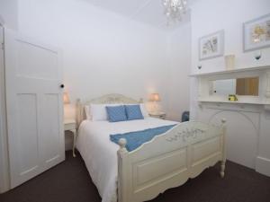 a bedroom with a white bed with a blue blanket at The Provincial in Minlaton