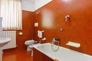 an orange tiled bathroom with a tub and a toilet at Residence Bonetti in Rabbi +144 photos