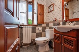 a bathroom with a toilet and a sink and a window at Lolo in Villaviciosa