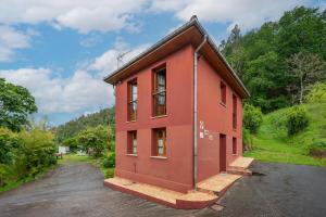 a small red building on a parking lot at Lolo in Villaviciosa