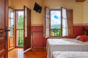 a bedroom with two beds and windows with a view at Lolo in Villaviciosa