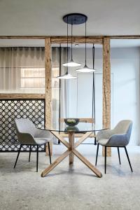 a dining room with a table and two chairs at Truma Swing Luxury in Merano +8 photos
